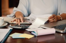 Hands of female entrepreneur working with bills and documents
