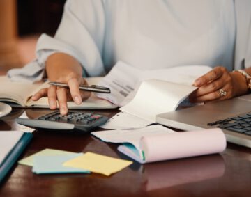 Hands of female entrepreneur working with bills and documents